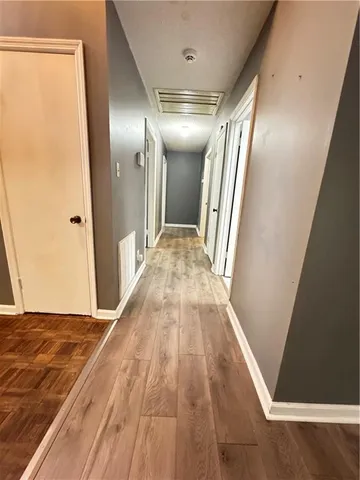 a view of hallway with stairs and wooden floor