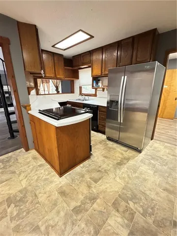 a kitchen with stainless steel appliances granite countertop a stove a sink and a refrigerator