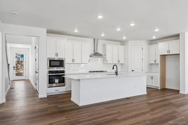 a large kitchen with stainless steel appliances and a refrigerator