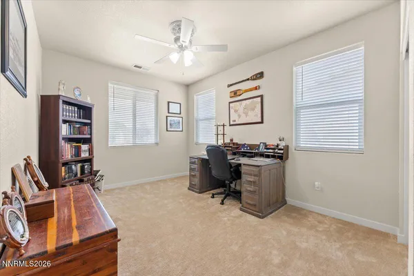 a view of a workspace with furniture and a window