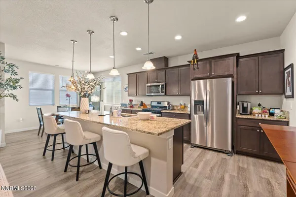 a kitchen with refrigerator and chairs