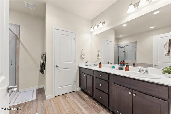 a bathroom with a double vanity sink mirror and shower