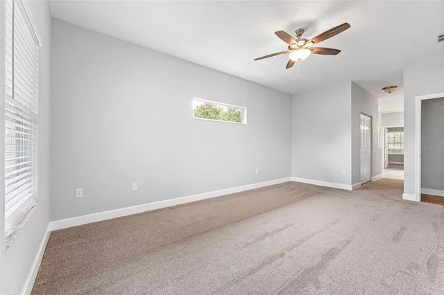 an empty room with a window and a fan