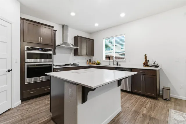 a kitchen with kitchen island a sink appliances and cabinets
