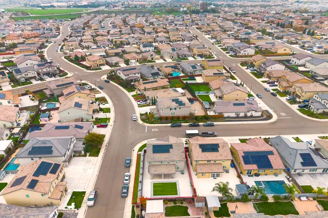 a front view of a house with garage and parking