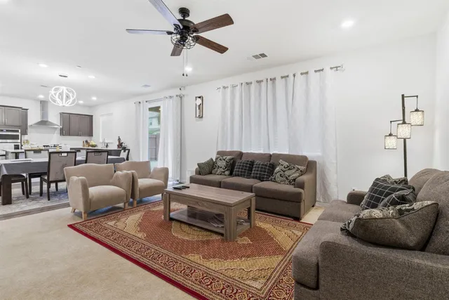 a living room with furniture ceiling fan and a rug