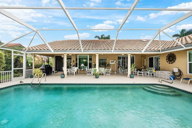 a front view of a house with swimming pool and patio