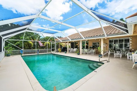 a view of a swimming pool with a patio and a yard
