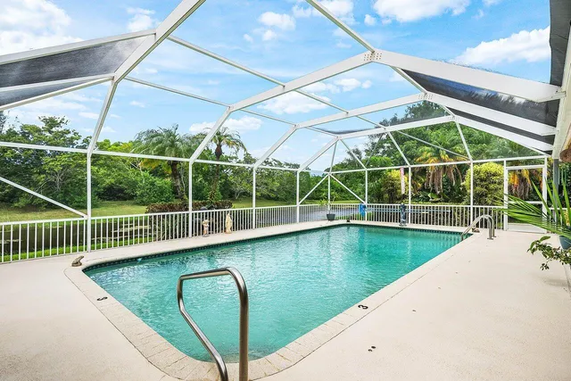 a view of a swimming pool with a yard in the background