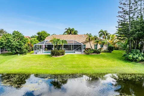 a view of a swimming pool with lawn chairs and plants