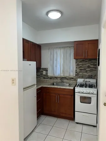 a kitchen with a stove sink and refrigerator