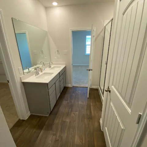 a view of a kitchen with kitchen island a sink wooden floor and appliances