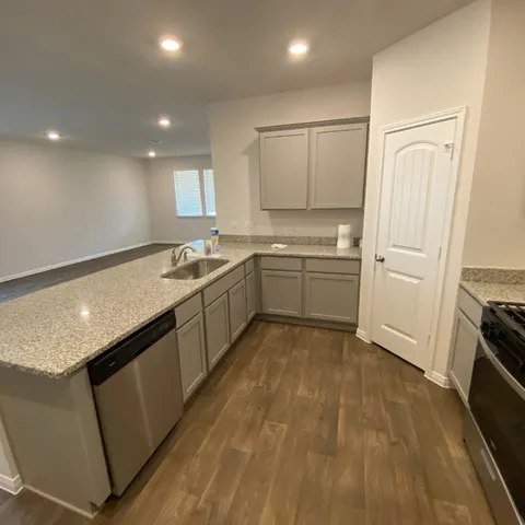 a kitchen with granite countertop a sink and cabinets