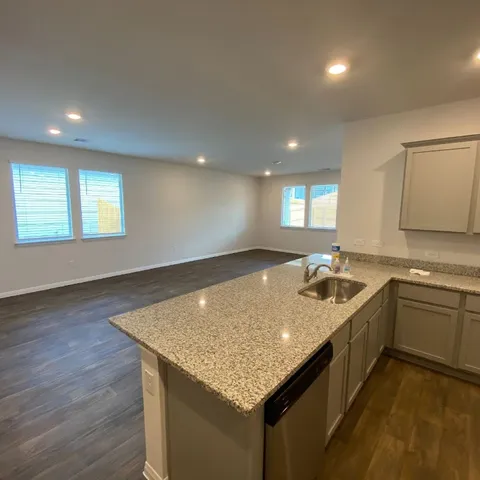 a kitchen with a sink and wooden floor