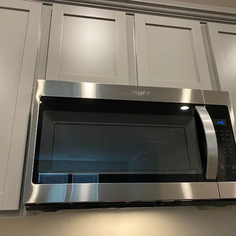 a living room with a wooden floor and white cabinet