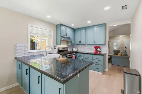a kitchen with granite countertop a sink a counter and cabinets