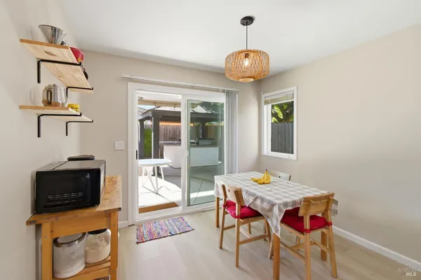 a dining room with wooden floor a chandelier a wooden table and chairs