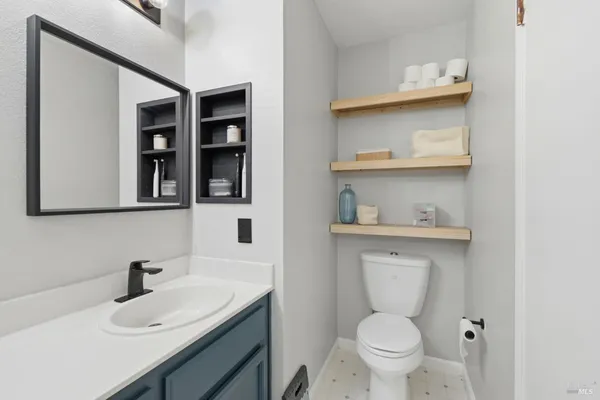 a bathroom with a sink a toilet and a mirror
