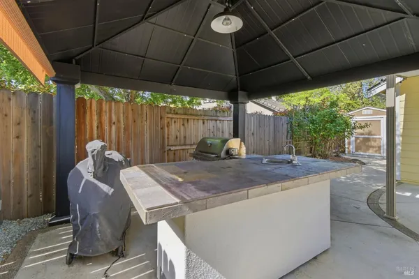 a view of a patio with table and chairs under an umbrella