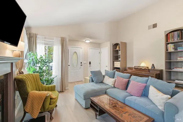 a living room with furniture a flat screen tv and a fireplace