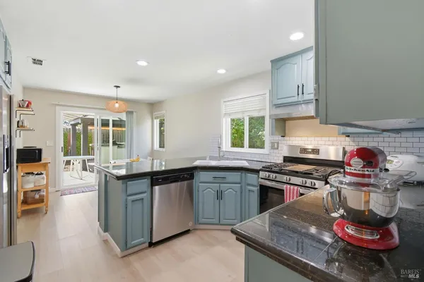 a kitchen with stainless steel appliances granite countertop a sink stove and refrigerator