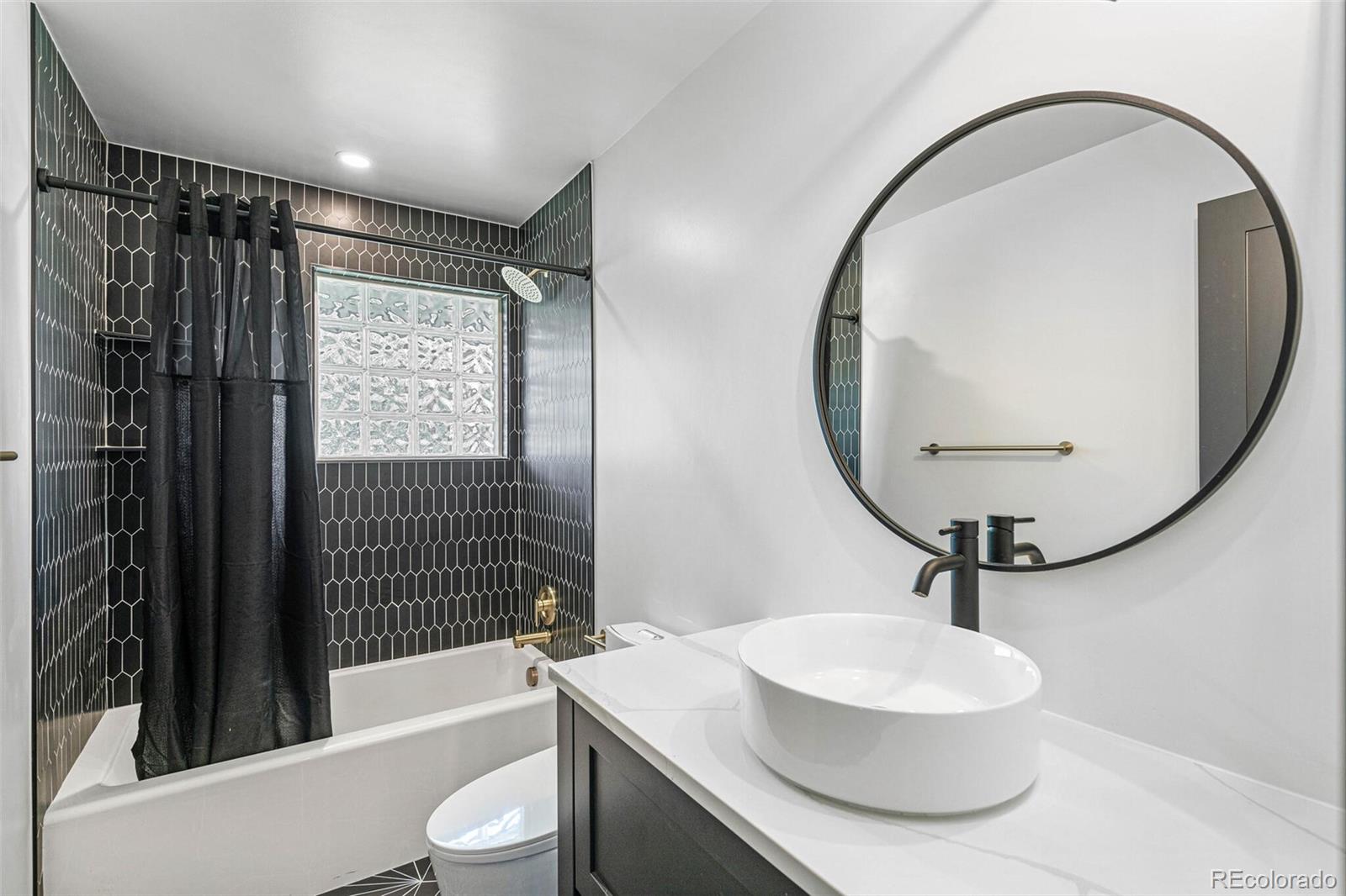 17 Rangeview Drive Wheat Ridge, CO 80215 - Photo 20 of 50 a bathroom with a sink a toilet and a mirror
