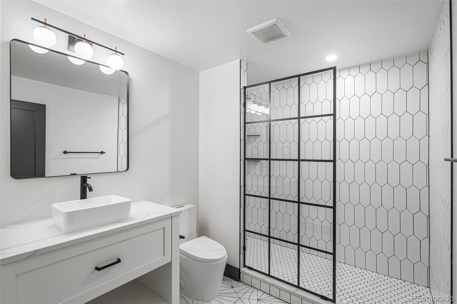 17 Rangeview Drive Wheat Ridge, CO 80215 - Photo 26 of 50 a bathroom with a toilet a sink and mirror