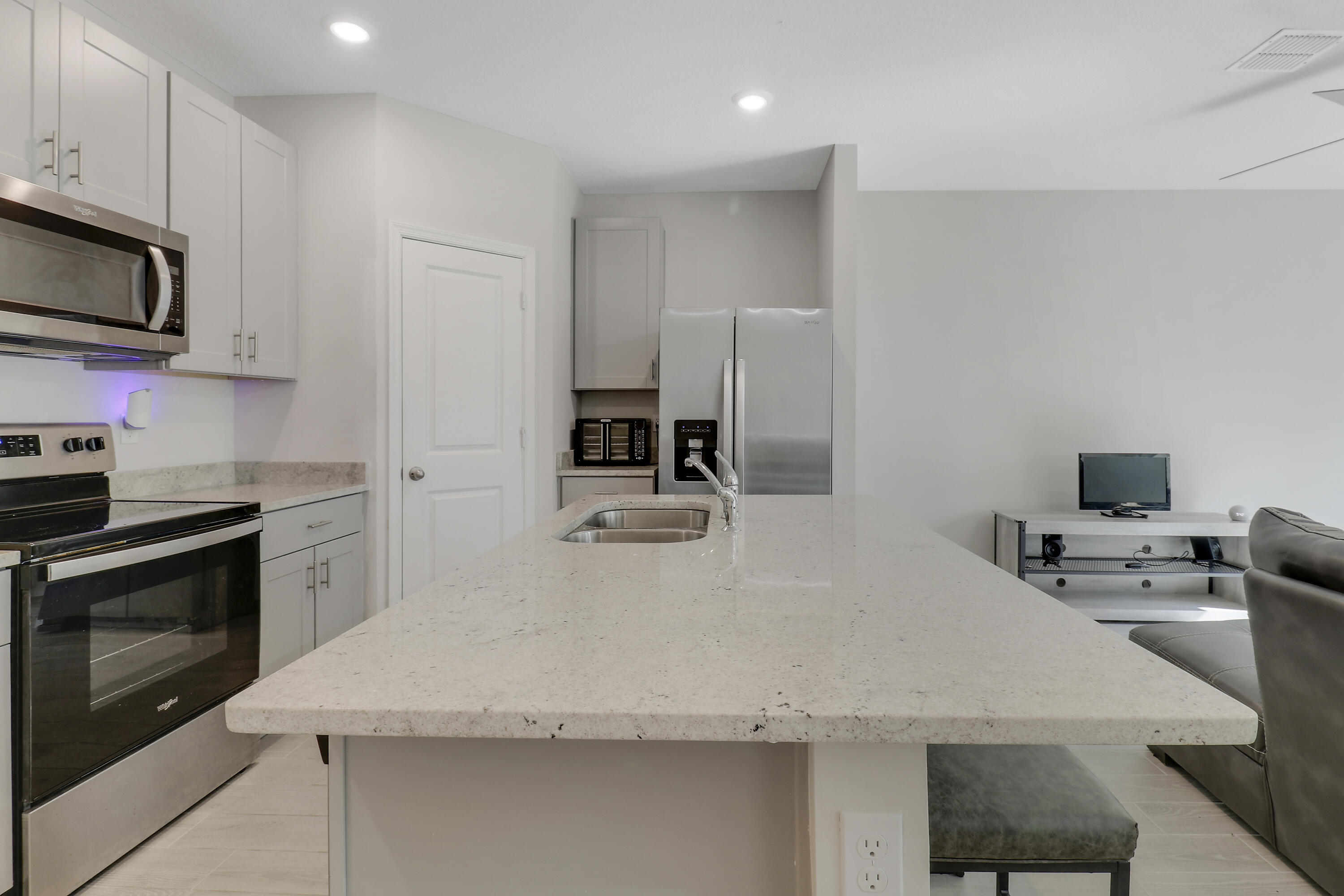 3903 Southeast Mentmore Lane Stuart, FL 34997 - Photo 16 of 35 a kitchen with kitchen island a stove sink and microwave
