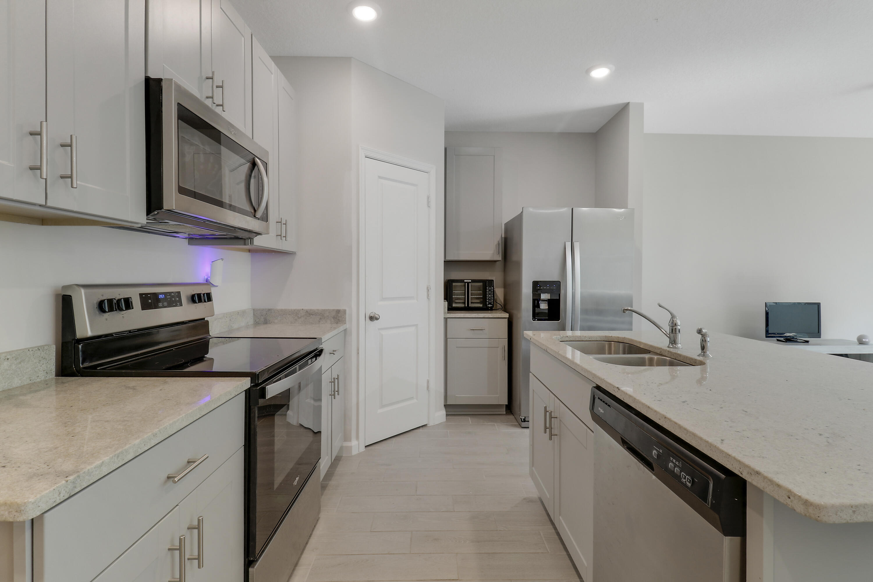 3903 Southeast Mentmore Lane Stuart, FL 34997 - Photo 17 of 35 a kitchen with stainless steel appliances granite countertop a sink stove microwave and refrigerator