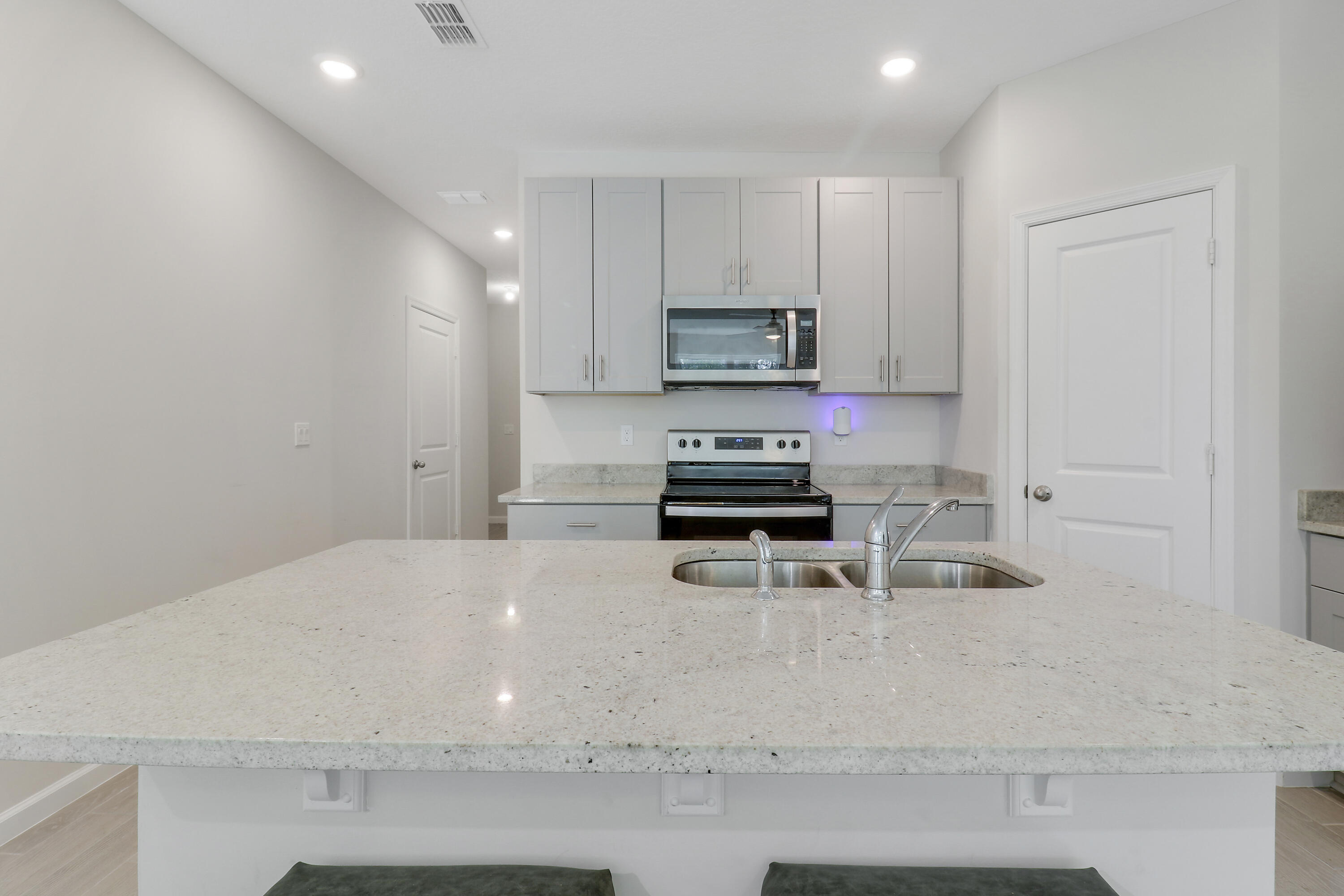 3903 Southeast Mentmore Lane Stuart, FL 34997 - Photo 18 of 35 a kitchen with kitchen island a sink a stove a microwave a counter top and cabinets