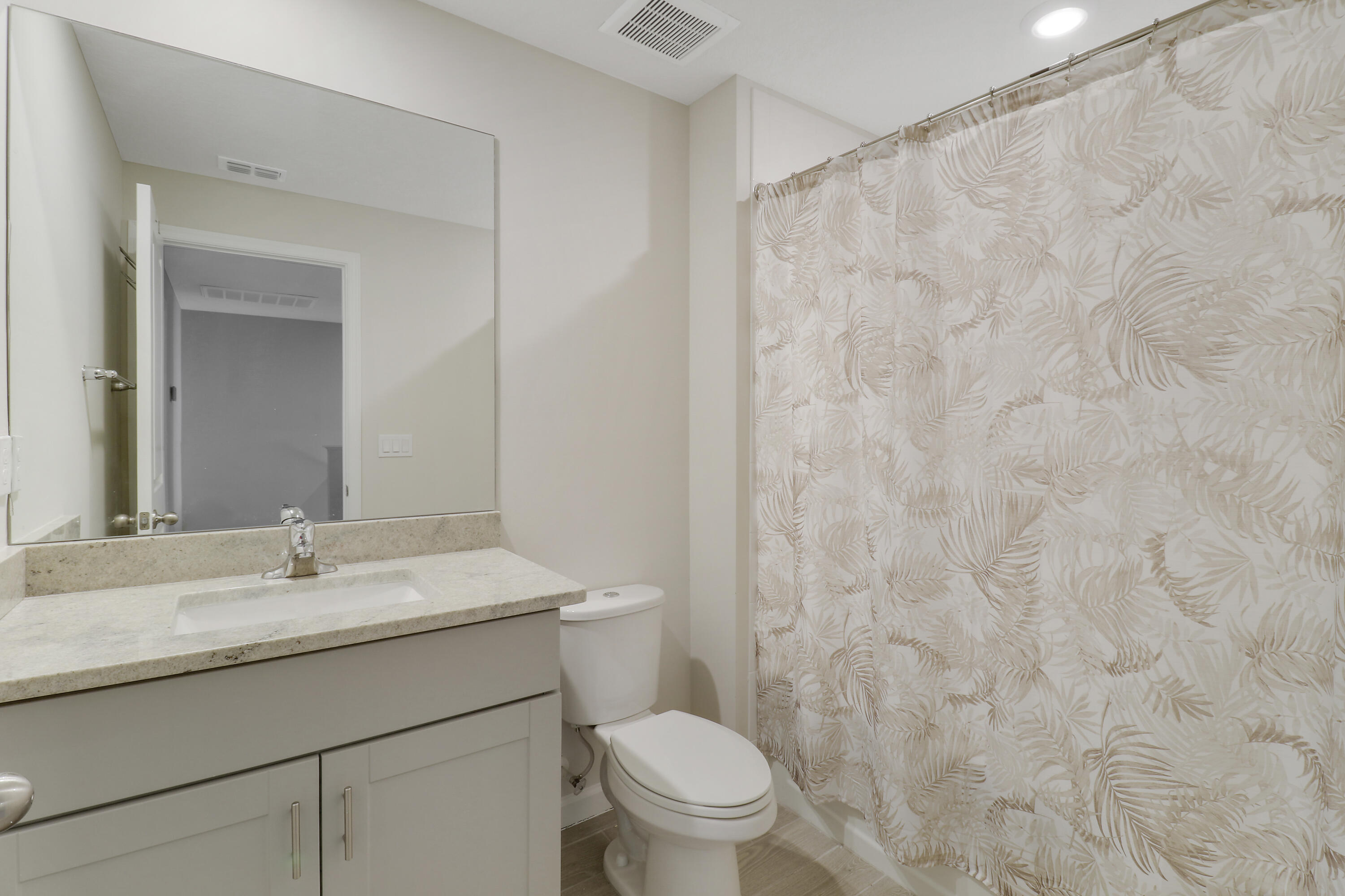 3903 Southeast Mentmore Lane Stuart, FL 34997 - Photo 27 of 35 a bathroom with a sink a toilet and a mirror