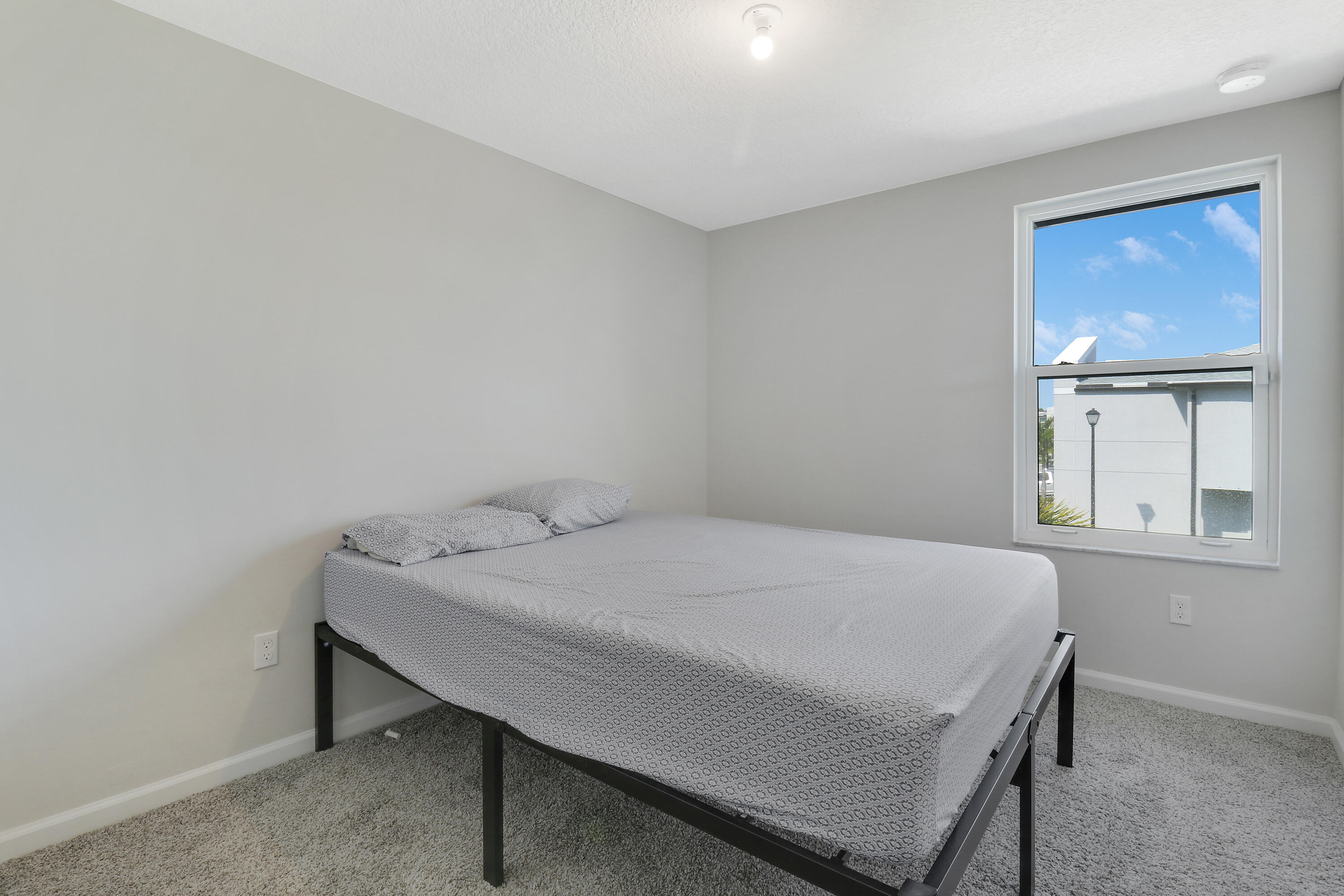 3903 Southeast Mentmore Lane Stuart, FL 34997 - Photo 29 of 35 a bedroom with a bed and window