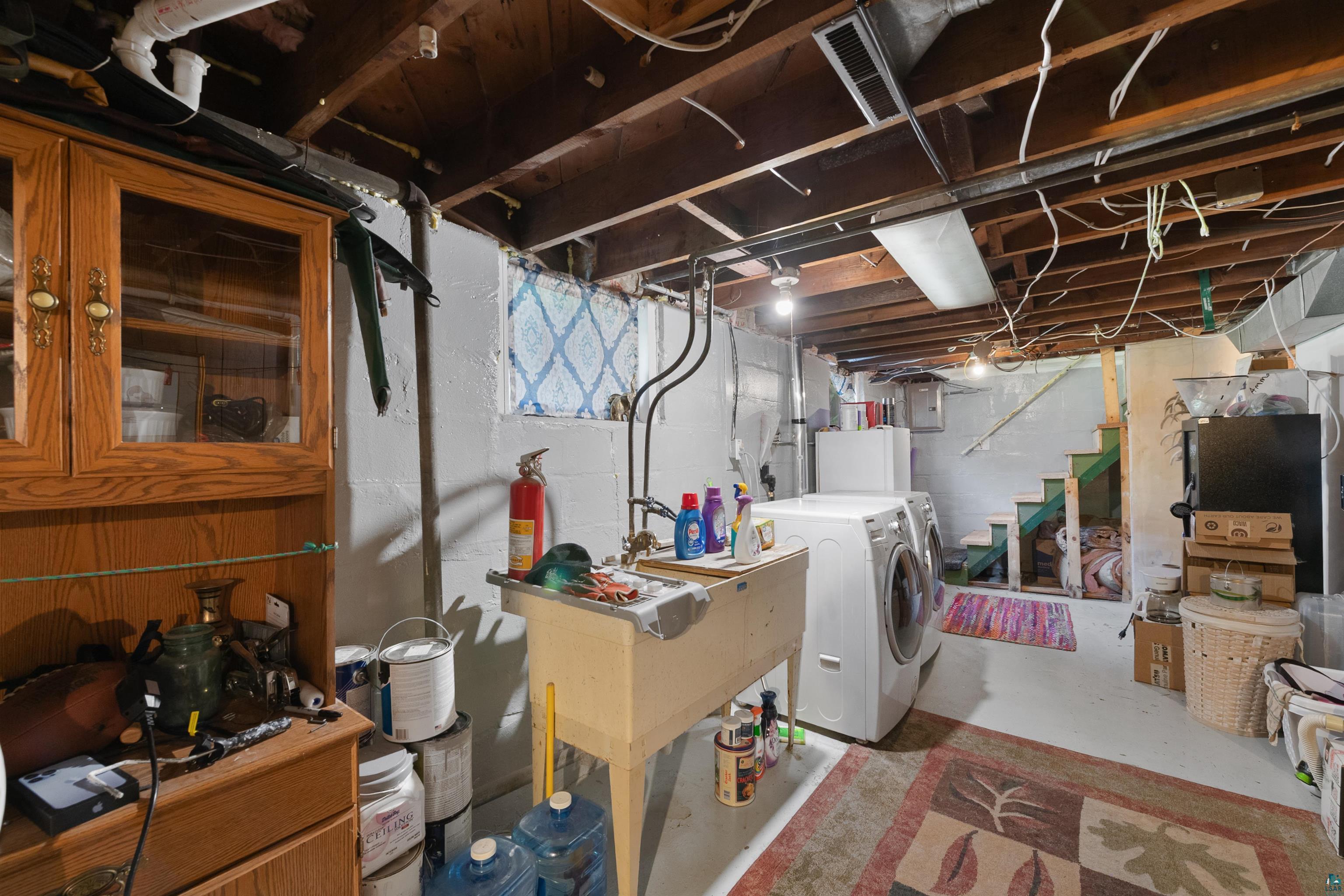 3209 Chestnut Street Duluth, MN 55806 - Photo 21 of 28 Utility room with exposed ceiling joists, laundry sink, and white painted concrete walls