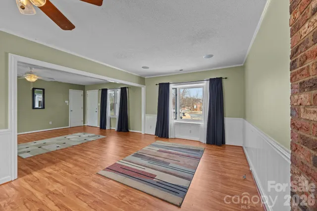 a view of a bedroom with wooden floor and windows