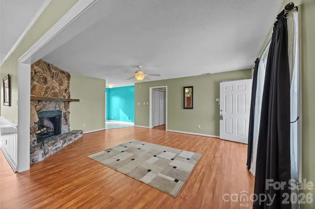 a view of a livingroom with wooden floor and a fireplace