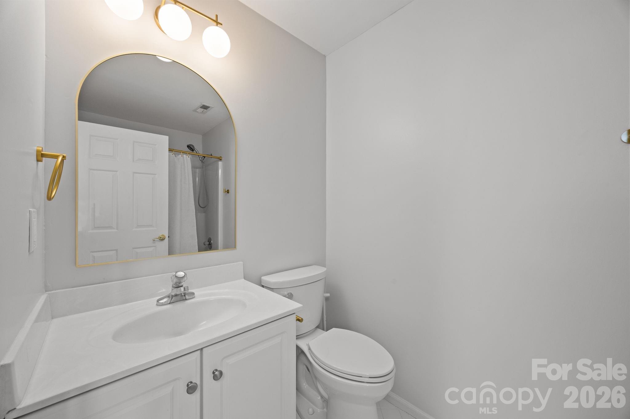 5243 Mintridge Road Mint Hill, NC 28227 - Photo 30 of 43 a bathroom with a toilet a sink and mirror