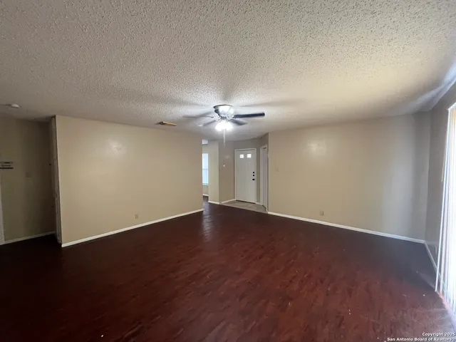 a view of an empty room with wooden floor