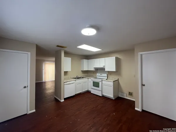 a kitchen with a stove top oven a sink dishwasher and a refrigerator with wooden floor