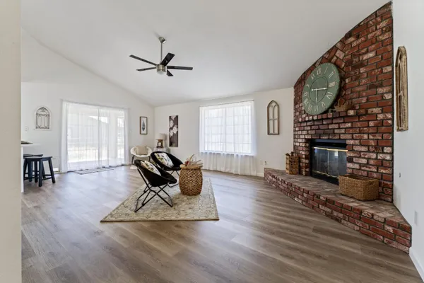 a living room with furniture a fireplace and a floor to ceiling window