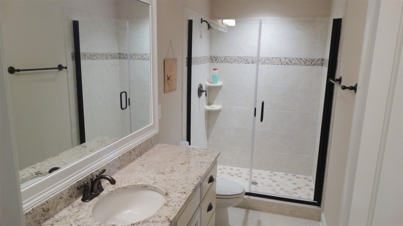1308 Trinity Circle Raleigh, NC 27607 - Photo 13 of 25 Bathroom with Custom-Tiled Shower and glass door is roomy and open to both Bedroom #2 and the hallway. Bathroom