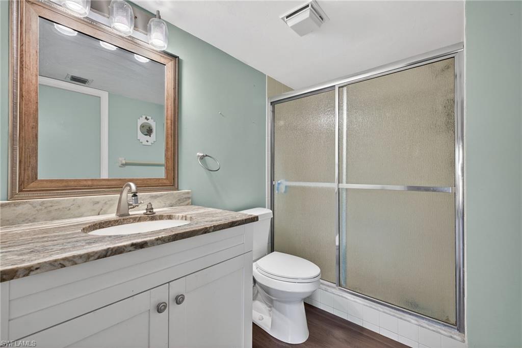 1223 Commonwealth Circle, Unit F201 Naples, FL 34116 - Photo 18 of 25 a bathroom with a granite countertop sink toilet and shower