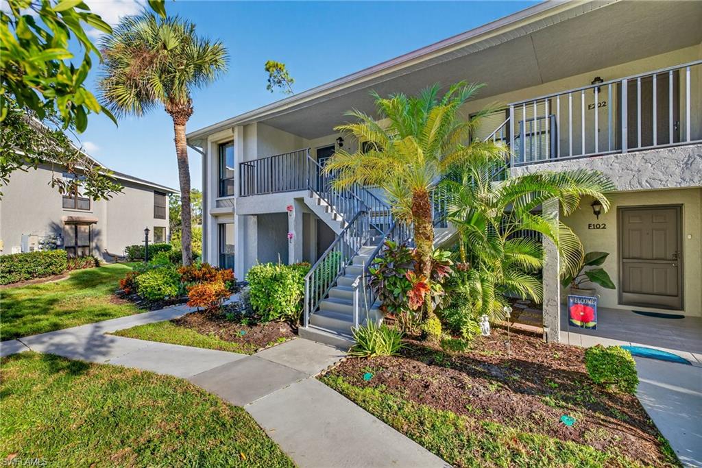 1223 Commonwealth Circle, Unit F201 Naples, FL 34116 - Photo 23 of 25 a front view of a house with a yard