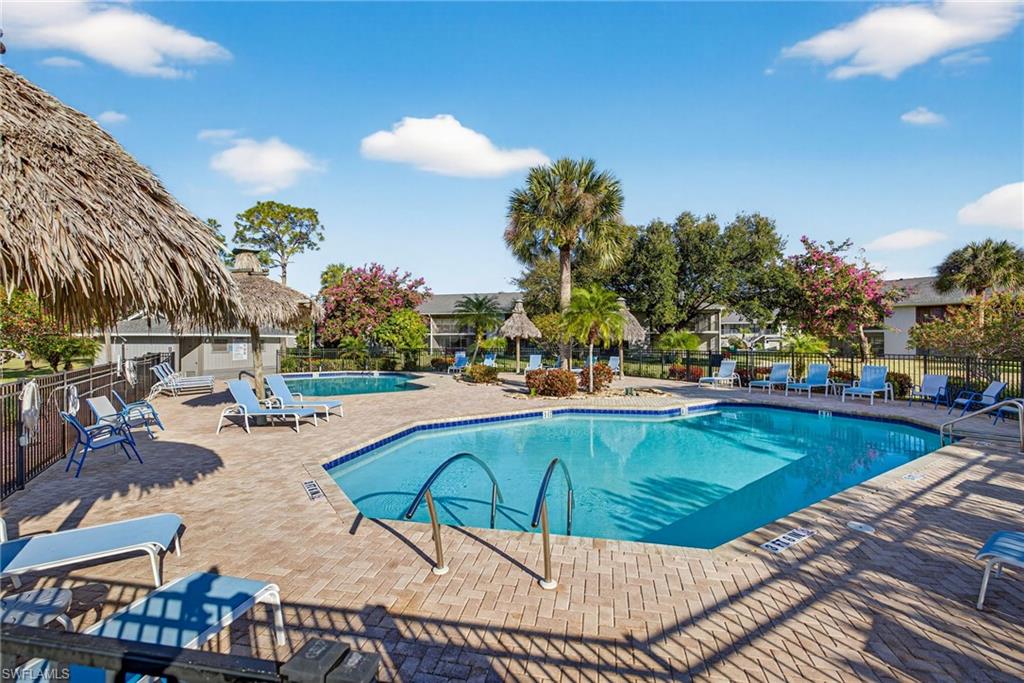 1223 Commonwealth Circle, Unit F201 Naples, FL 34116 - Photo 25 of 25 a view of a swimming pool and lounge chairs