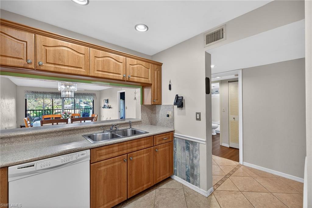 1223 Commonwealth Circle, Unit F201 Naples, FL 34116 - Photo 5 of 25 a kitchen with stainless steel appliances granite countertop a refrigerator and a sink