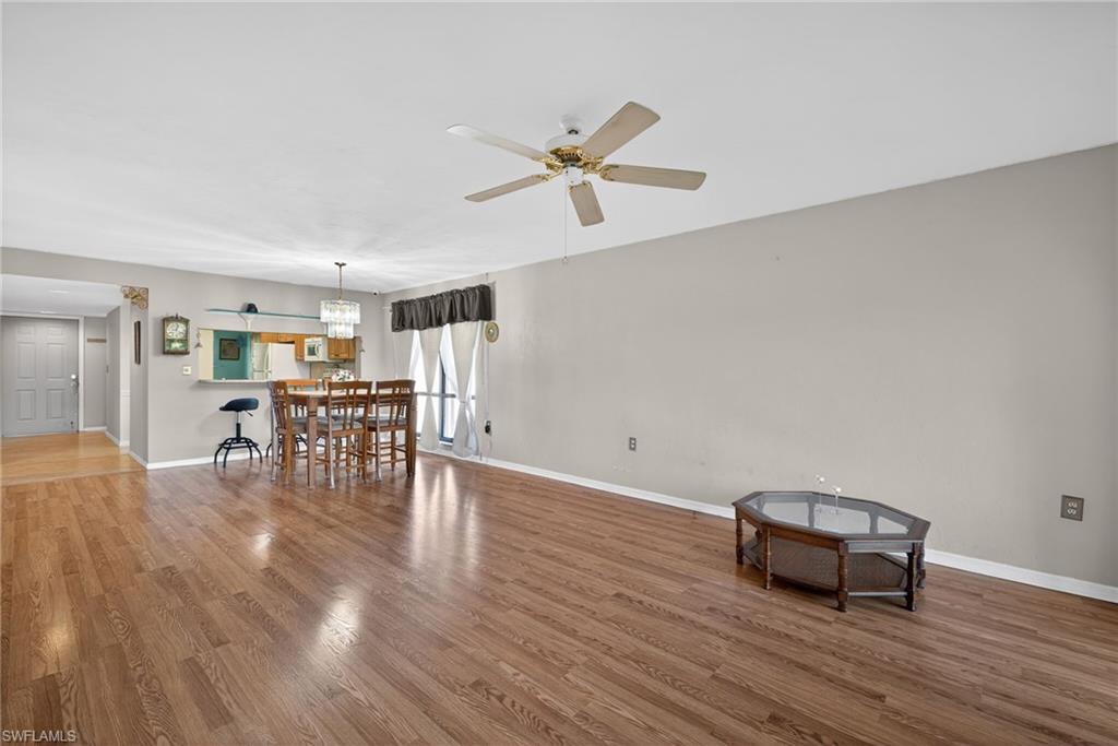 1223 Commonwealth Circle, Unit F201 Naples, FL 34116 - Photo 7 of 25 a living room with furniture and wooden floor