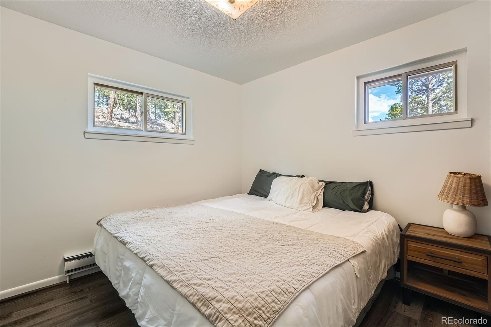 28669 Mountain View Road Conifer, CO 80433 - Photo 13 of 40 a large bed in a white room