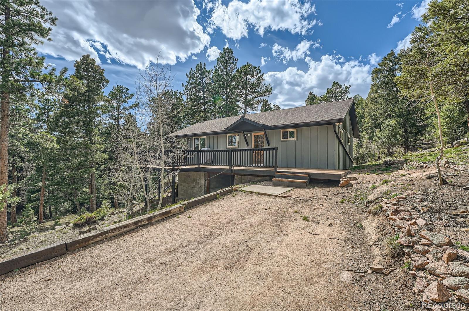 28669 Mountain View Road Conifer, CO 80433 - Photo 22 of 40 a front view of a house with a yard