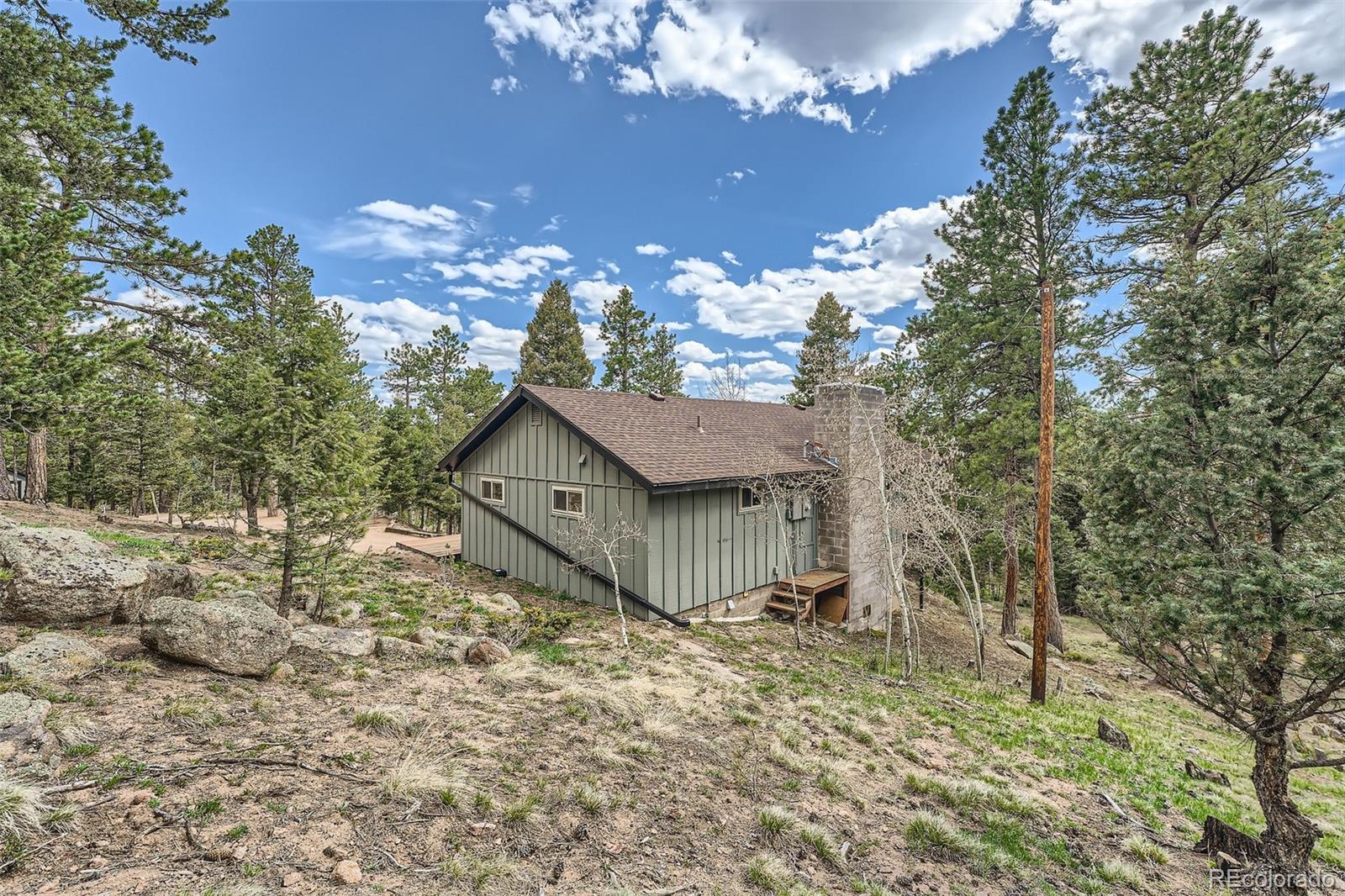 28669 Mountain View Road Conifer, CO 80433 - Photo 25 of 40 a view of a house with a tree in the yard