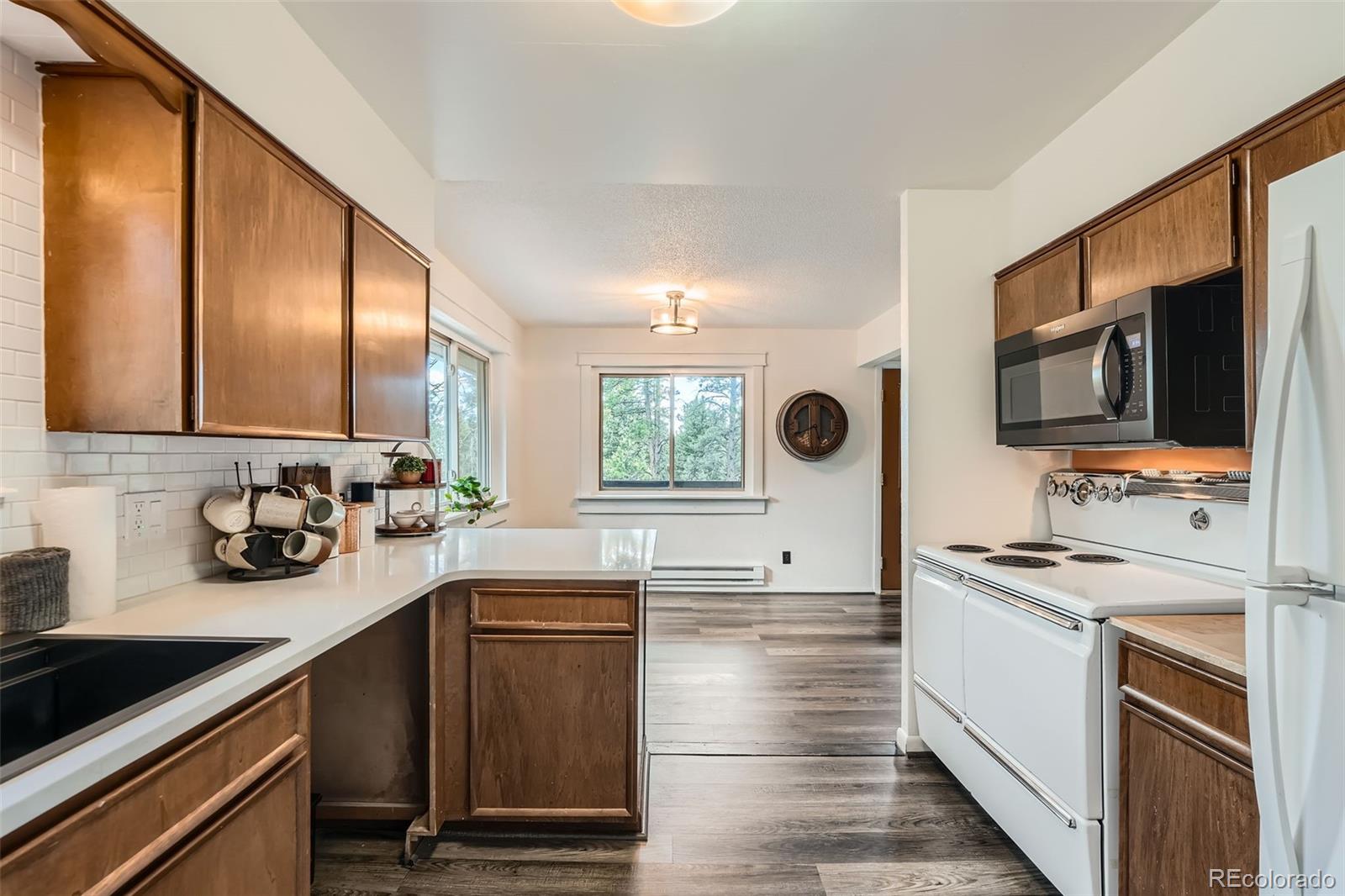 28669 Mountain View Road Conifer, CO 80433 - Photo 7 of 40 a kitchen with a sink stove and microwave