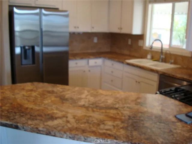 a kitchen with granite countertop a stove and a sink